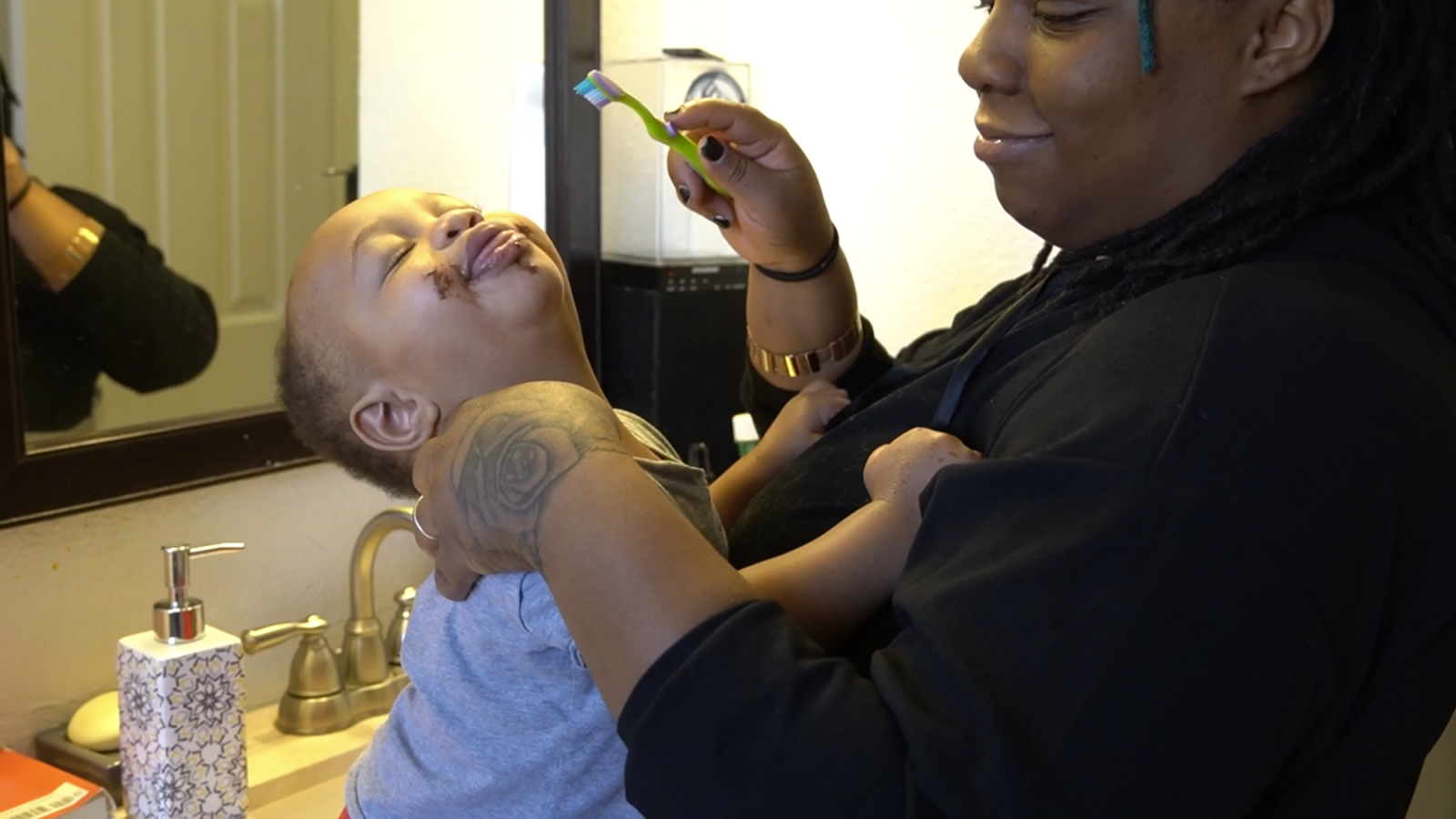 Magan brushing Sincere's teeth