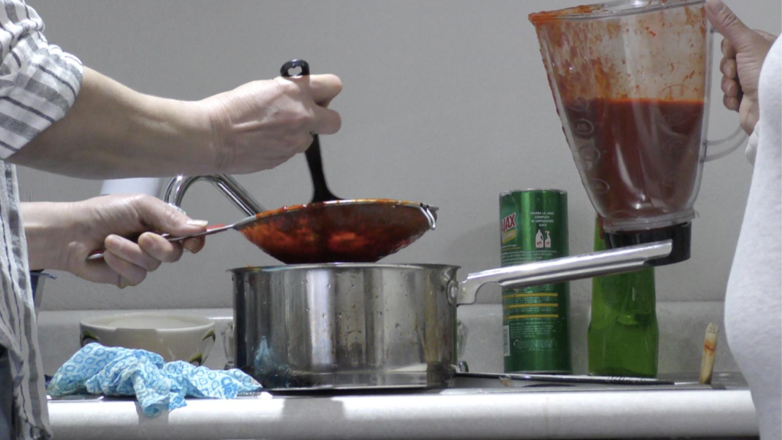 Two people cooking, one with ladle and one with container