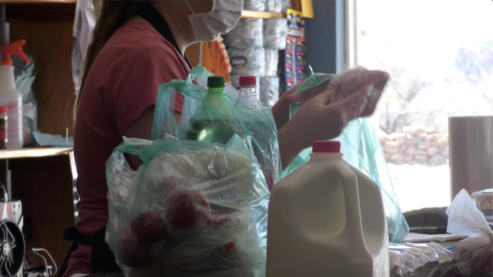 Checkout counter of grocery store with milk and bags of food