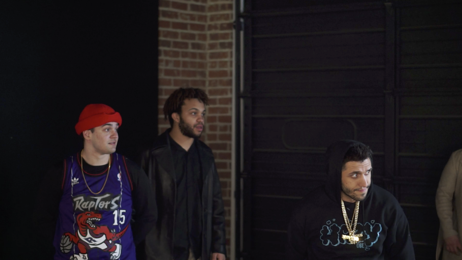 Three people in a theater space looking to their left
