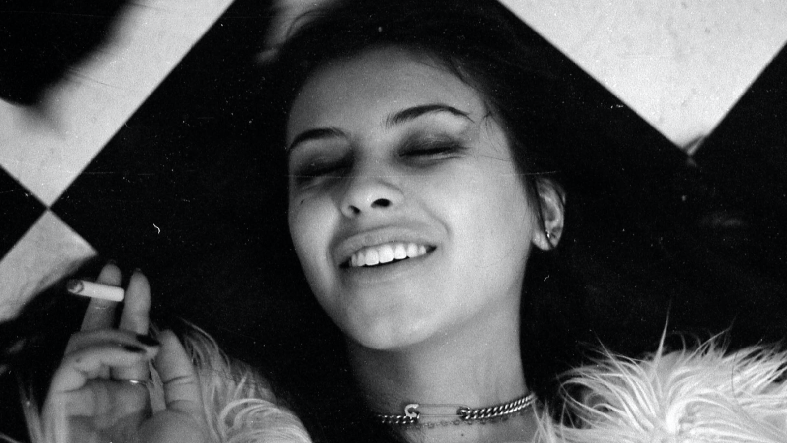 Woman laying on floor smoking a cigarette