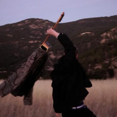 Samuel Holding a Guitar in Front of Mountains