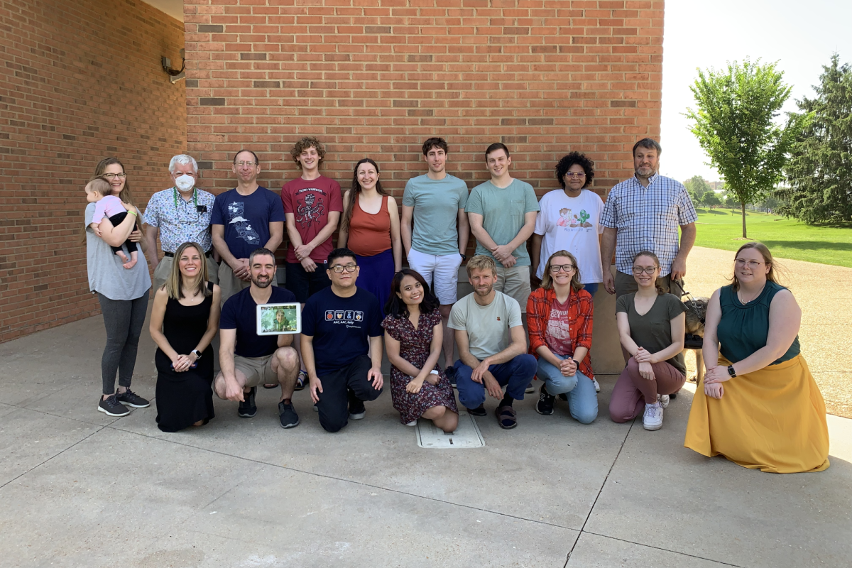 large group of attendees of 2022 St. Louis retreat posed in front of brick wall