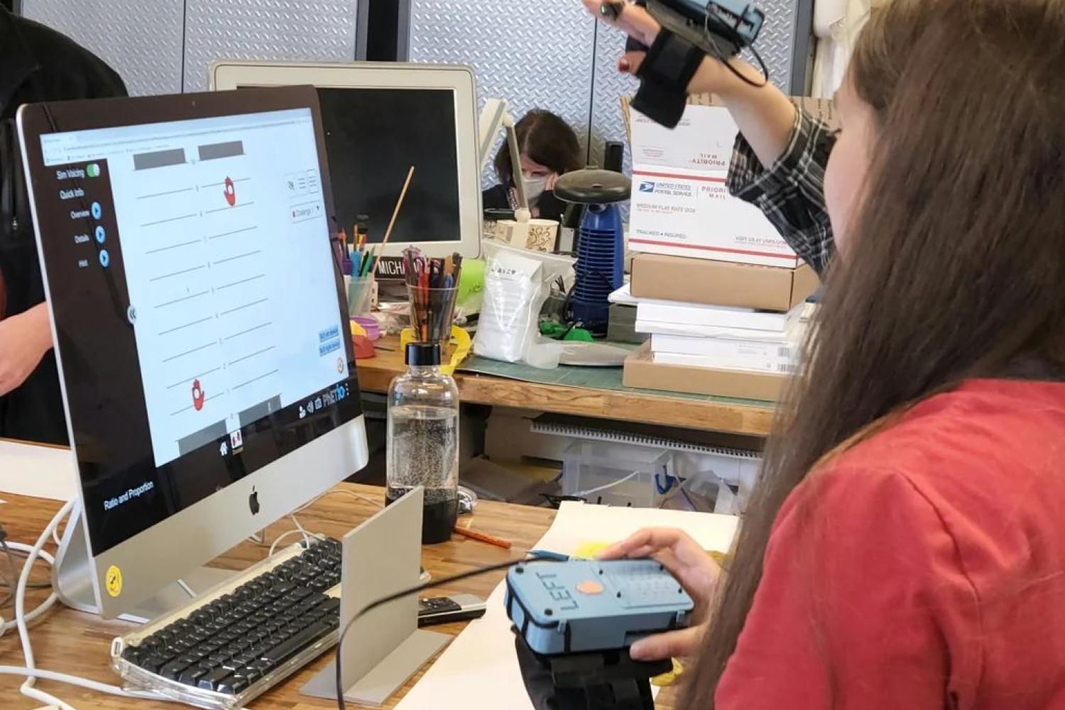 girl looking at PhET simulation Ratio and Proportion holding sensory extension device