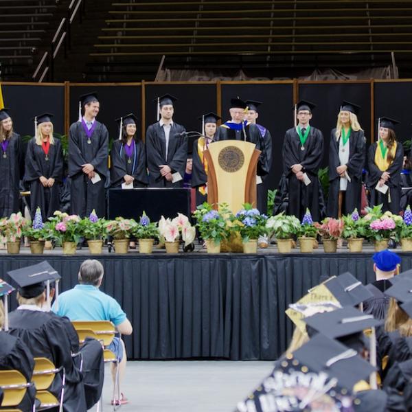 Director of the Honors Program Dick Olson recognizes each of the Latin Honors graduates and their senior theses