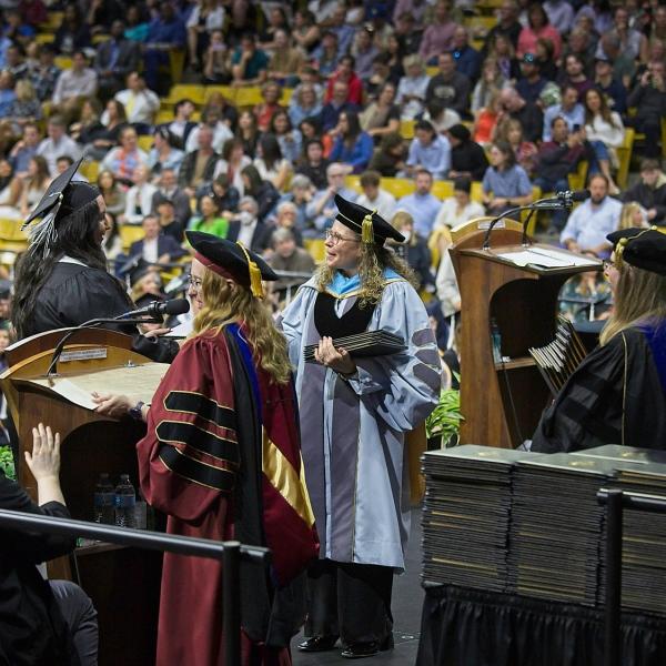 Emcee Jenn Stratford read 500 names as the graduates crossed the stage. We were thrilled to have CU Regent Ilana Spiegel help hand out diploma (covers). Her daughter graduated with a psych degree!