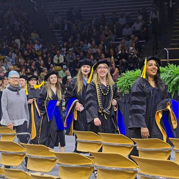 The PhDs process to their seats, as guided by staff member Kate Bell