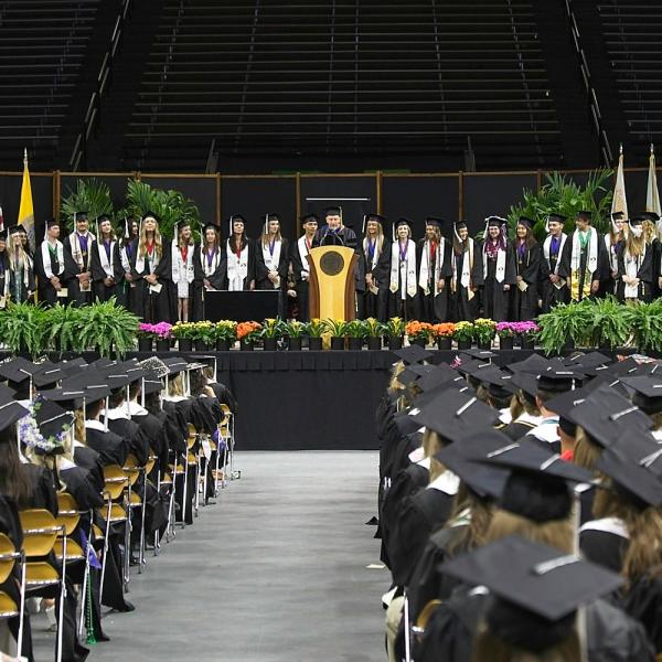 Faculty member and Honors Council representative McKell Carter introduces and congratulates those graduating with Latin Honors. The most ever, 30+. They barely all fit on the stage.