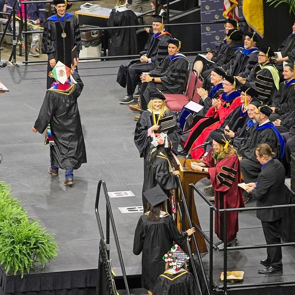 A birds-eye view of the graduates crossing the stage