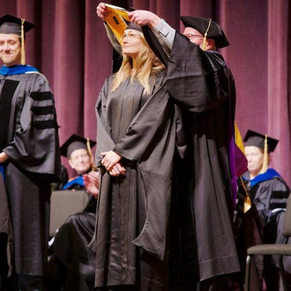 Clinical student Natasha Hansen is given her Master's hood by Professor Mark Whisman