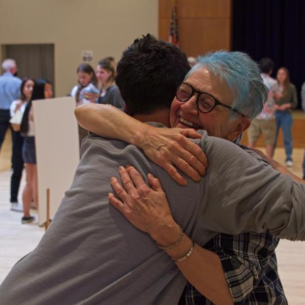 Staff URD coordinator Kate Bell gets a hug from faculty organizer Mike Baratta