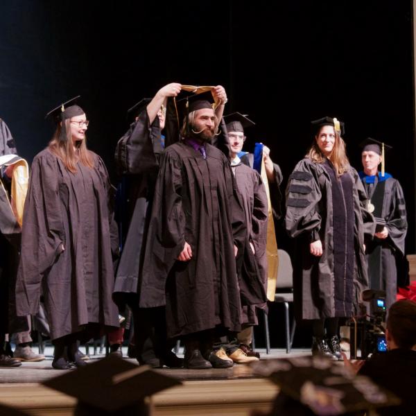 A Master's Degree was also awarded to Michael "Flux" Caruso, here hooded by Professor Irene Blair