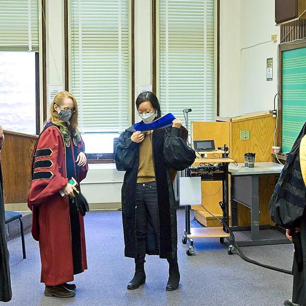 Given we haven't had an in-person ceremony in two years, the faculty try to remember how to put on their academic regalia before the ceremony