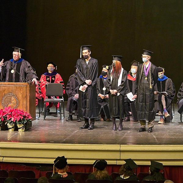 Professor Lew Harvey announces those graduating with Latin honors