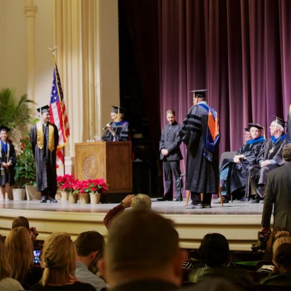 The students cross the stage to get a marble, a diploma cover, and a handshake