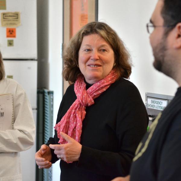 students and faculty in a lab talking