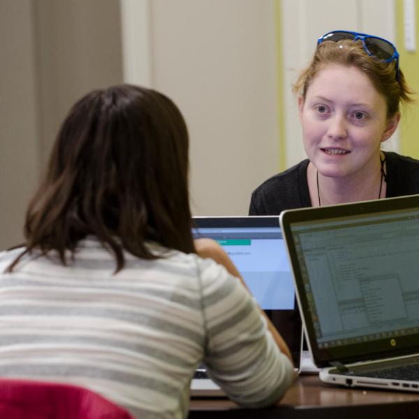 three students studying with laptops
