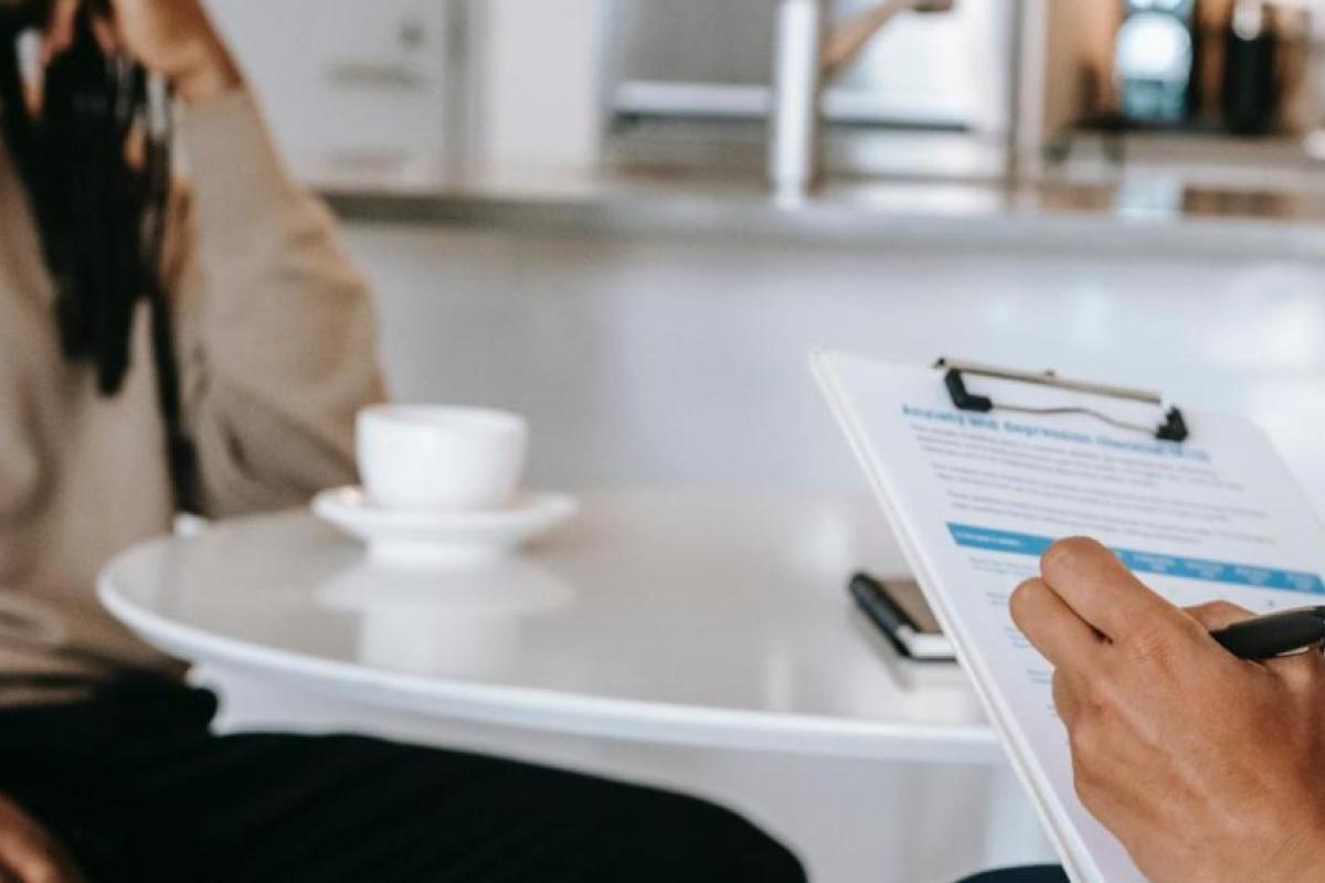 two people sitting at a table with clipboard