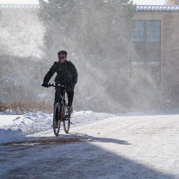 Person biking through campus on a snowy day