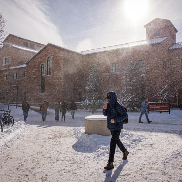 Student walking on campus during a snowy day