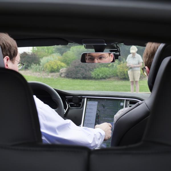 Two people driving in a car looking towards the dashboard
