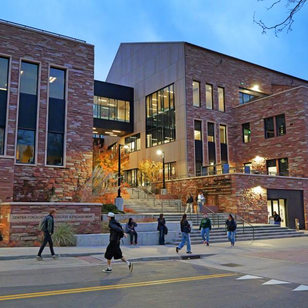 Students walking in front of the Center for Academic Success and Engagement building at the University of Colorado Boulder.