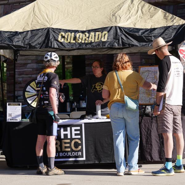 People interacting with a Bike to Work Day table at the Rec Center.