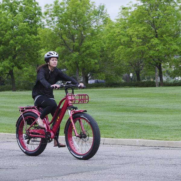 Person with a helmet riding an electric bike on CU Boulder campus