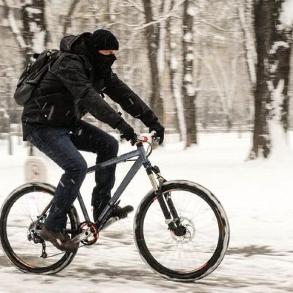 Man cycling in snowy conditions.