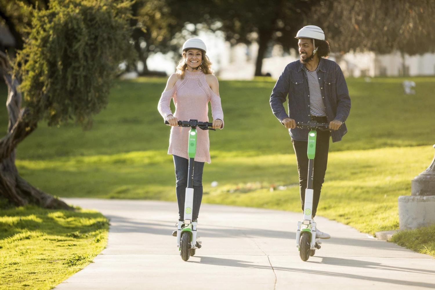 people riding lime electric scooters