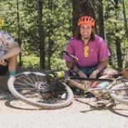 Image of five individuals sitting at the edge of a bike trail.