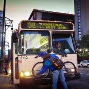 Rider loads their bike onto an RTD bus bike rack.