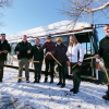 Employees perform a ribbon-cutting ceremony in front of an electric Buff Buses.