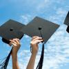 Hands holding graduation caps in the air
