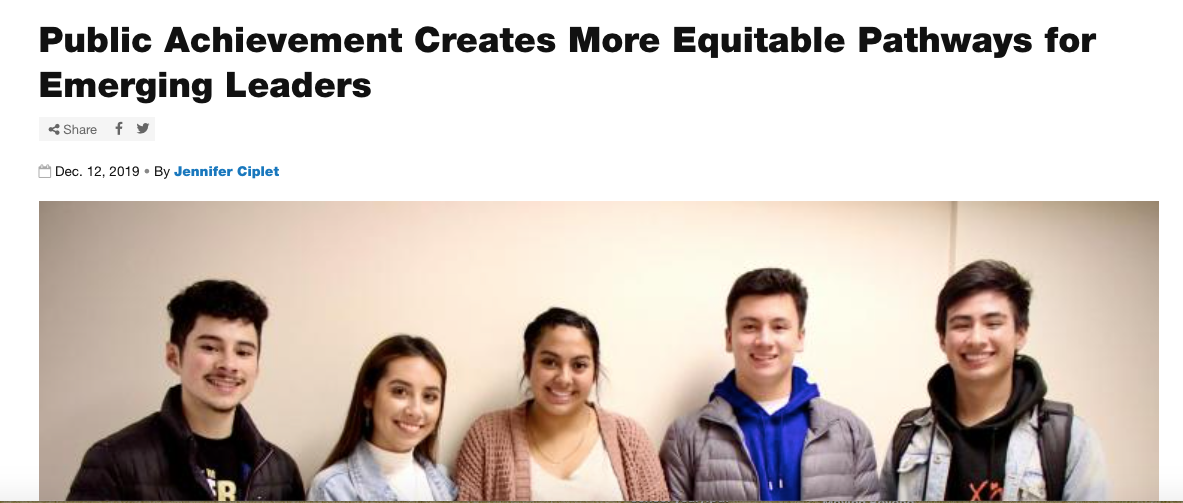 Five students stand against hallway wall smiling