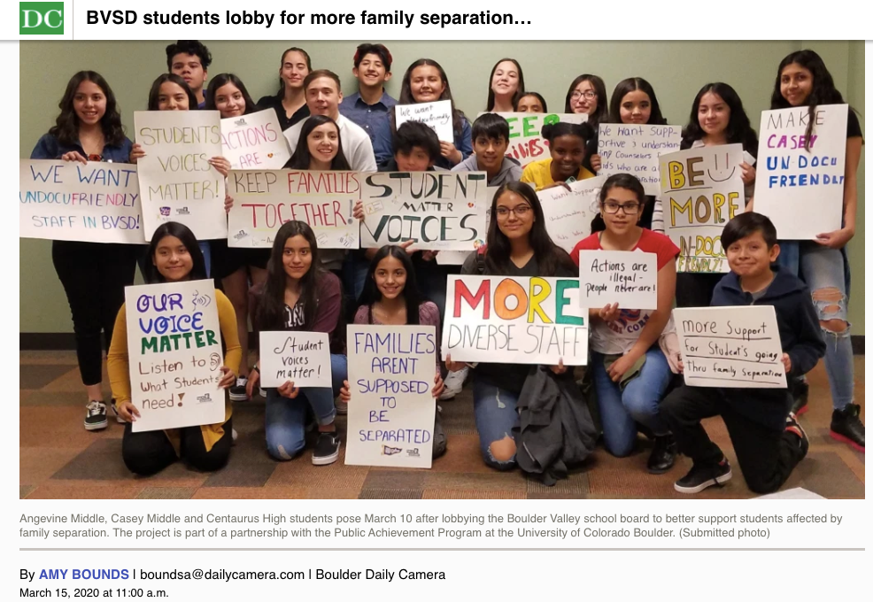 students gather holding signs to support immigration rights 