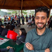 JD Mangat stands in front of crowd of youth at park gazeebo