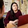 At computer talking with students