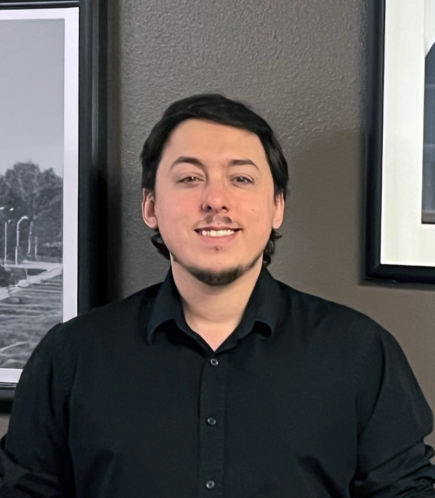 Andrew Escanuela in front of paintings