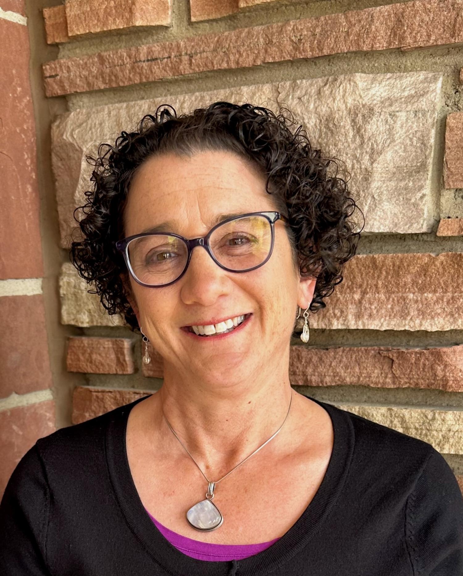 Michelle Albert standing in front of a brick wall