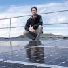 Joey Luther stood on top of a rooftop solar panel installation