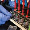 gloved hand testing lithium-ion batteries