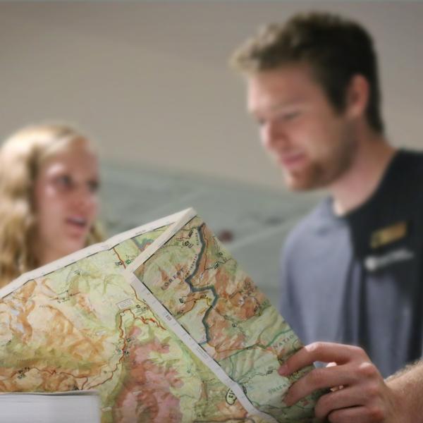 student and an outdoor program staffer looking at a map