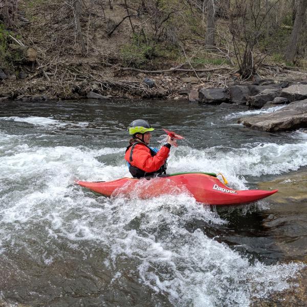student out in a kayak going over rapids