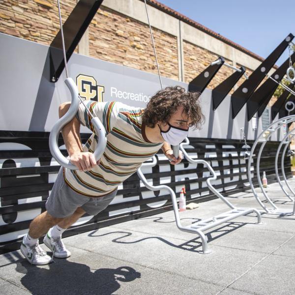 man in mask working at a fitness court