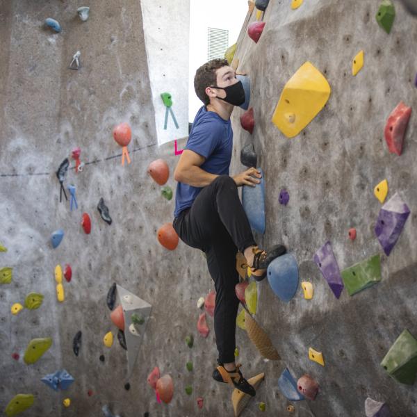 student climbing alone in the climbing gym