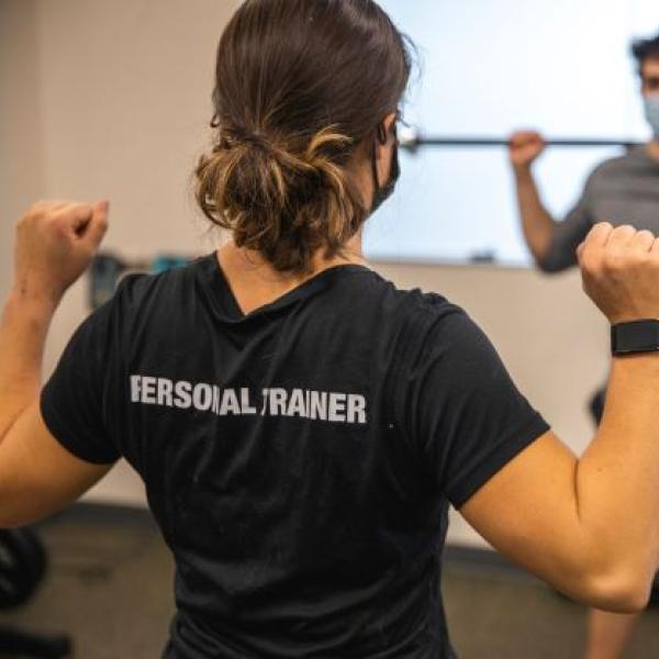 personal trainer showing someone how to squat