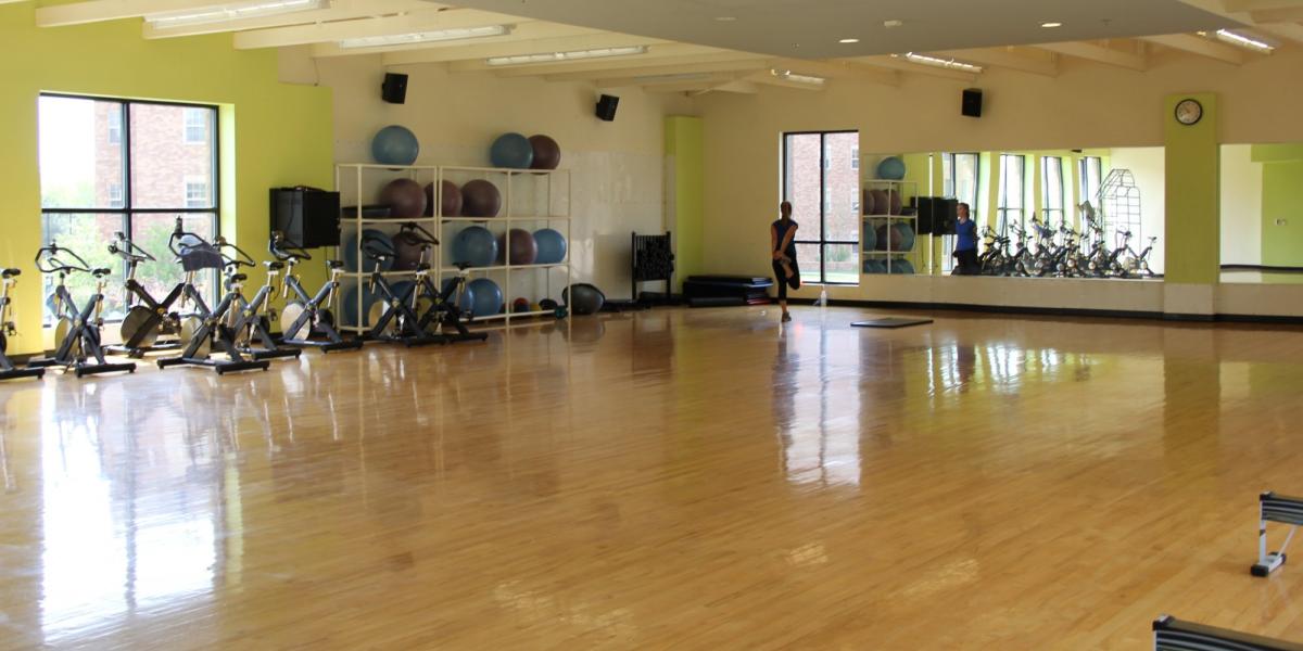 a large empty room with wooden floors and mirrored walls