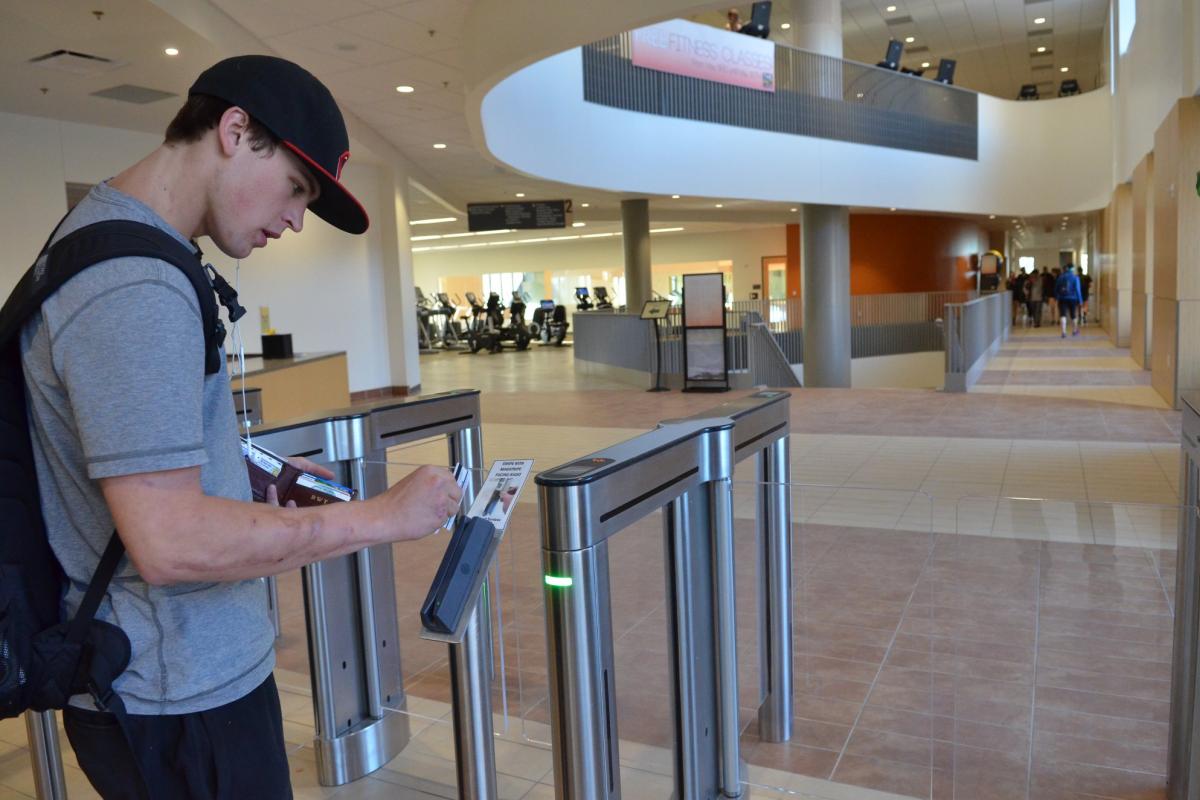 Male student swiping Buff OneCard to get into rec