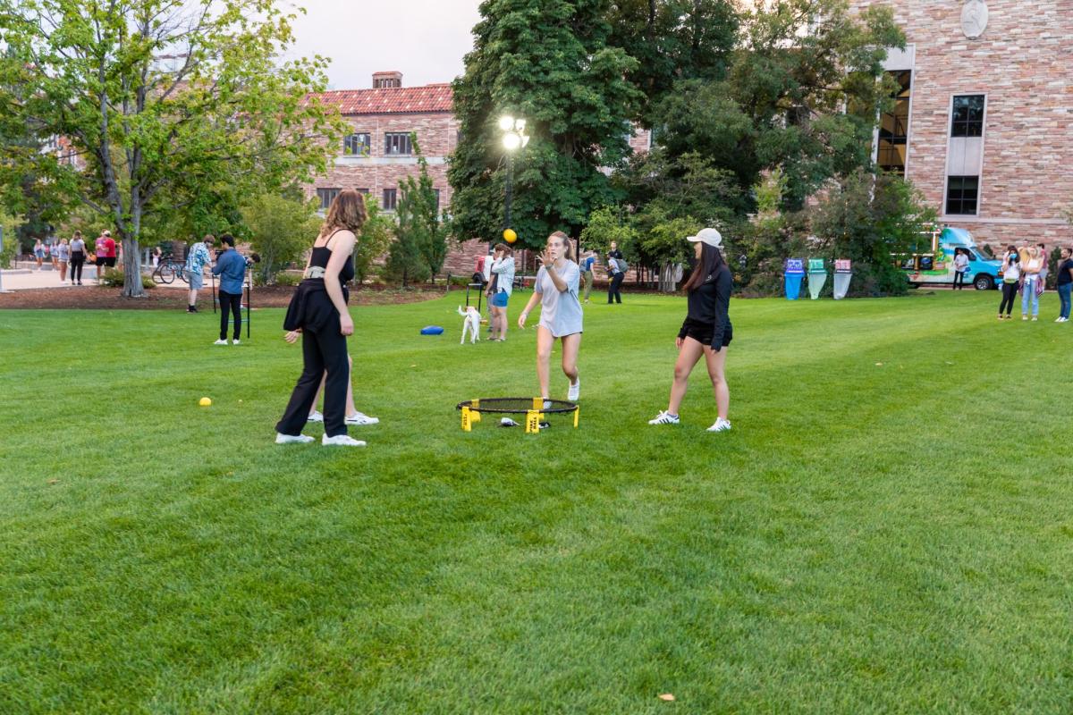 field by residence halls with students playing spikeball